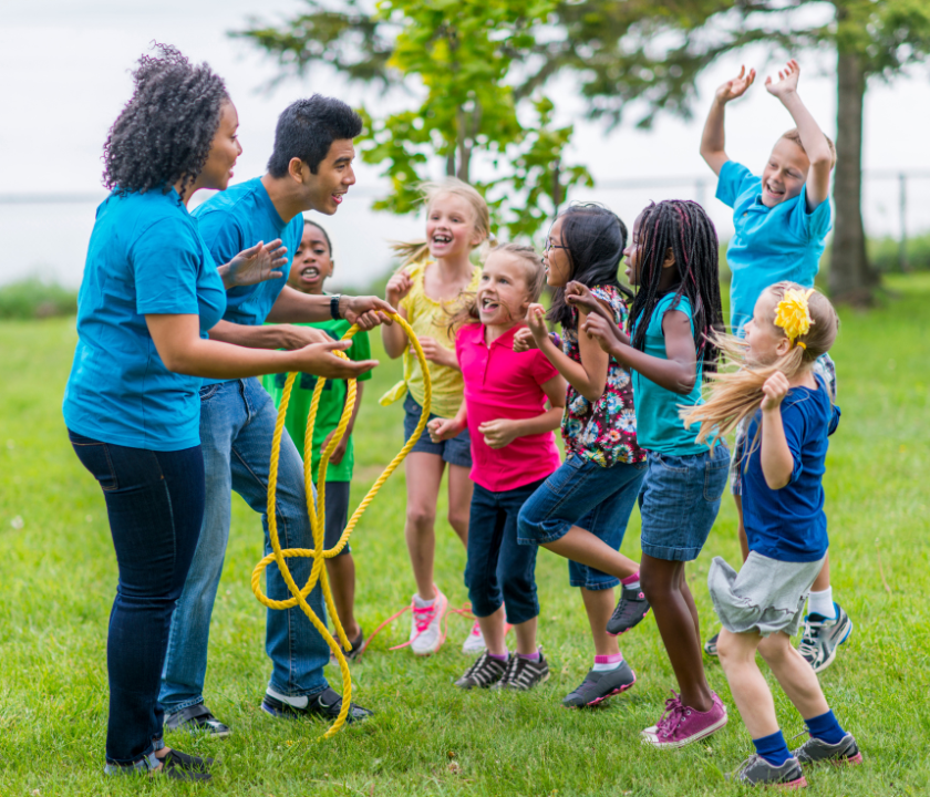 Leaders of a group of summer campers pass out activity.
